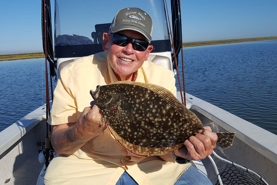 elderly man holding a flounder in corpus christi texas